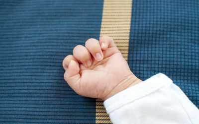 A newborn hand on blue background