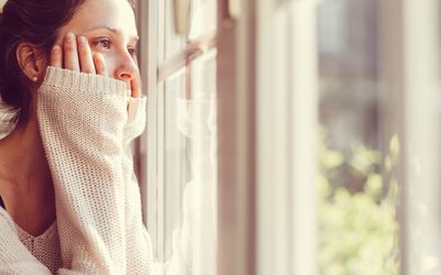 穿白毛衣的女人望着窗外。