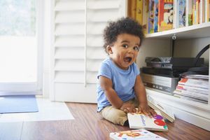 Baby smiling playing with book