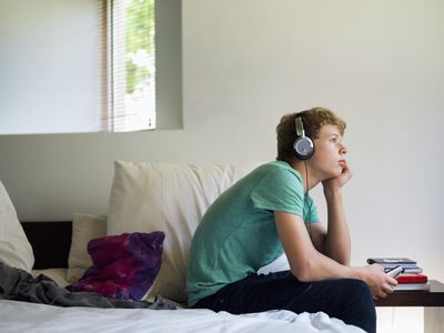 Teenage boy listening to music on a mobile phone
