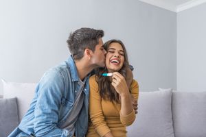 Happy couple looking at pregnancy test.