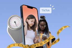 图片说明两名青少年在体重秤和卷尺的包围下看着他们的手机