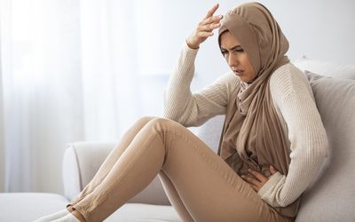 Woman experiencing acute abdominal pain as a symptom of ectopic pregnancy