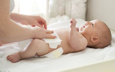 Mother changing baby's diaper