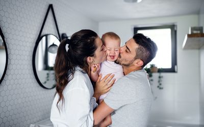一对夫妇抱着他们的孩子亲吻。