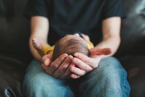 男子双手捧着婴儿。