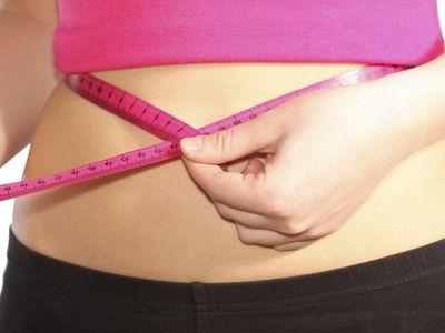 Girl with tape measure on waist