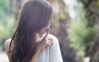 女人用手指捂着嘴，沉默着不孕和流产