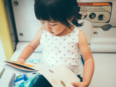 Toddler girl reading story book