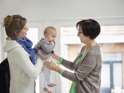 Woman giving her daughter to nanny