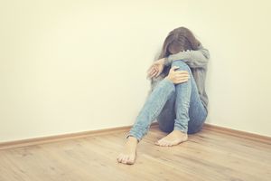 不开心的女孩坐在角落里