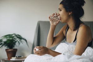 woman drinking water in bed