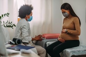 医生在检查孕妇时带着医用口罩。
