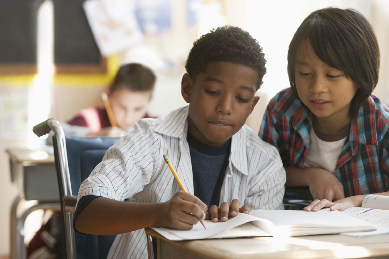 A student in a wheelchair does schoolwork.
