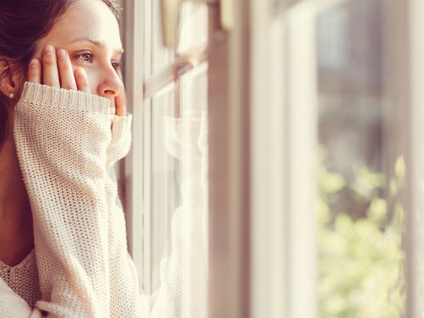 穿白毛衣的女人看着窗外。