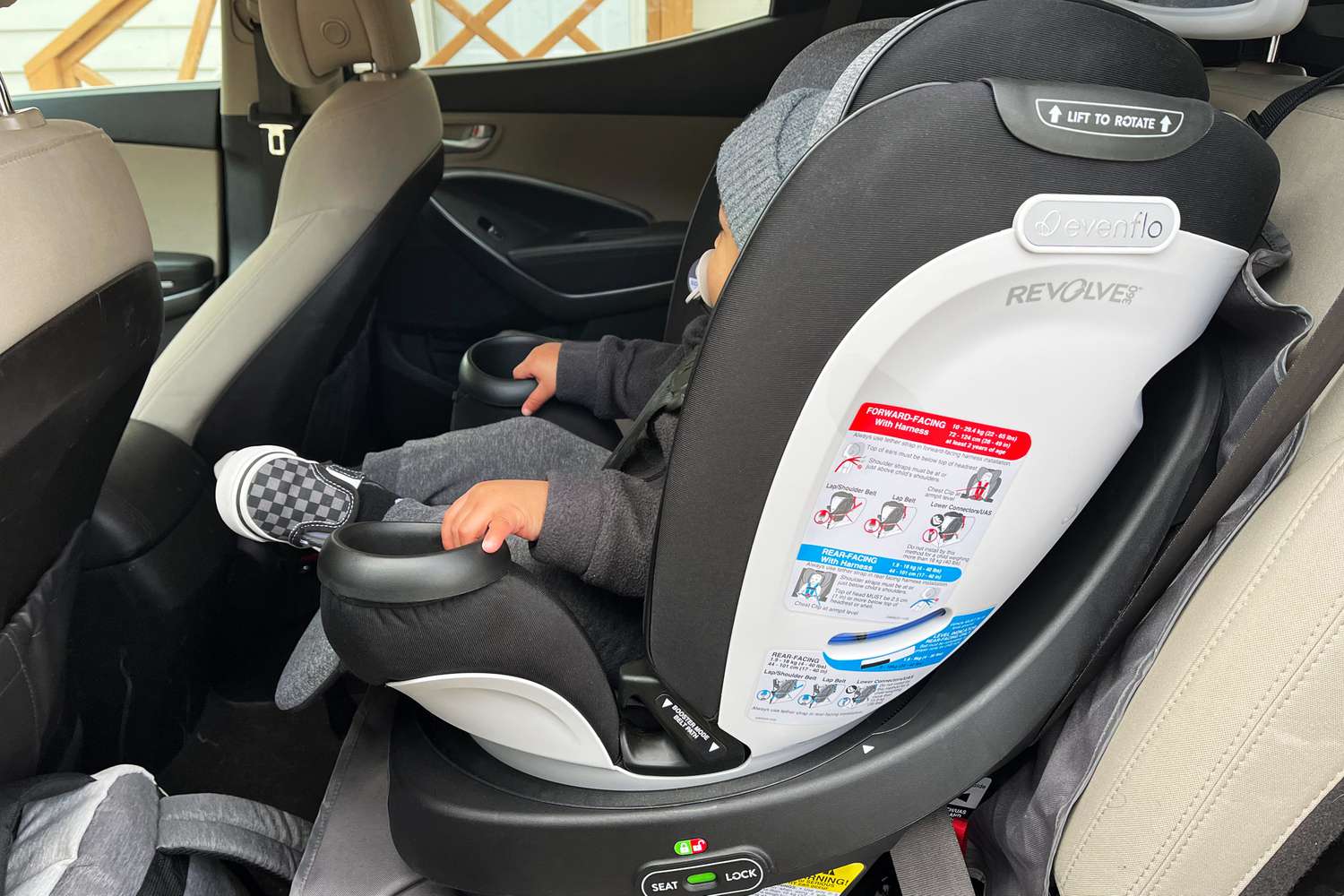 孩子坐在前夕nflo Gold Revolve360 Rotational All-In-One Convertible Car Seat