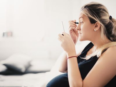 pregnant woman putting on makeup
