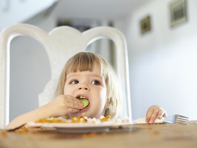 Little girl eating vegetables