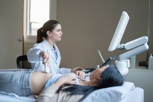 女医生正在做超声波扫描，看起来非常专注于病人