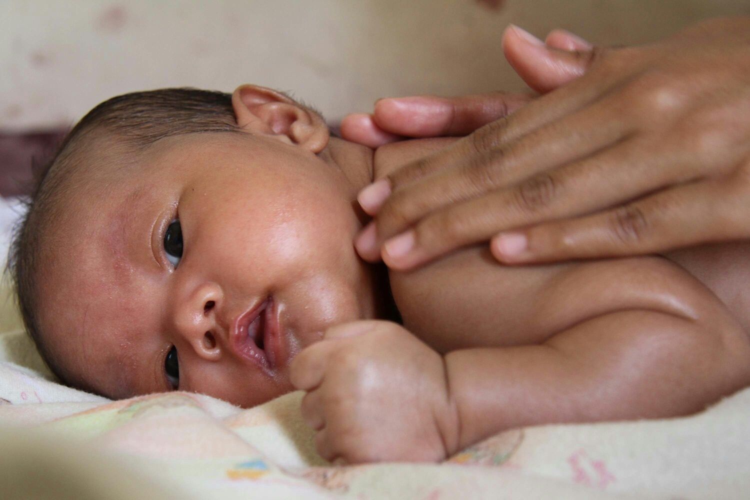 Mother massaging infant