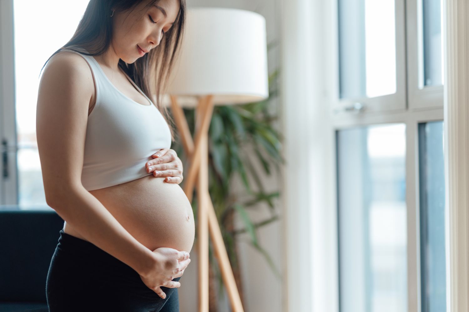 孕妇低头凝视着孕妇的肚子。