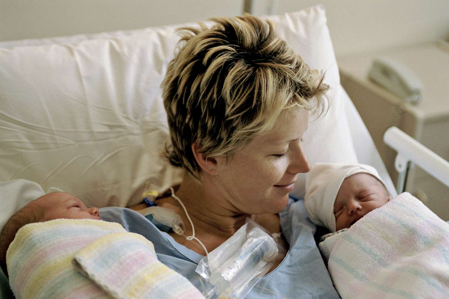 Mother holding newborn twins in the hospital