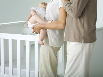 父母在孩子的婴儿床旁闲逛