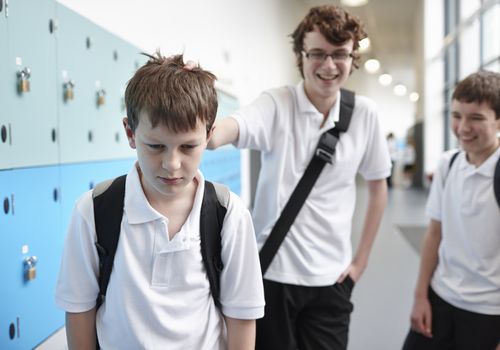 middle school boy being bullied in hallway near lockers