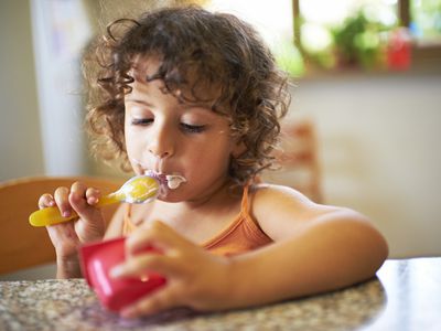 Toddler eating yogurt