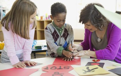 Students with teacher drawing road sign in art class