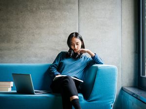 坐在图书馆沙发上的年轻女子