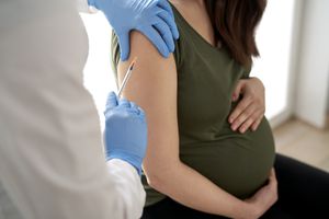 Pregnant person being administered vaccine