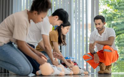 First aid training for pediatric patients, in a classroom where medical students are practicing with a dummy