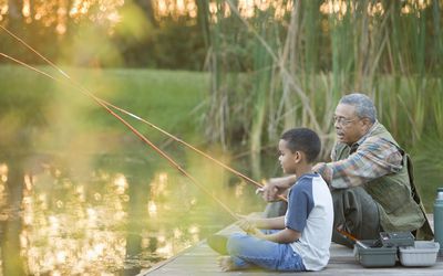 Grandfather and grandson fishing on pier