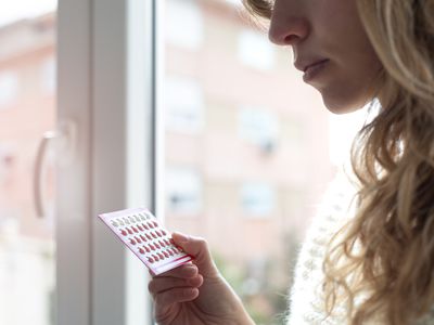 Woman holding birth control pills