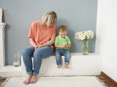 Young woman and baby boy playing with flowers