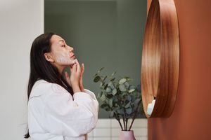 年轻女子在脸上涂保湿霜