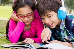 kids with headphones listening to audiobook and reading