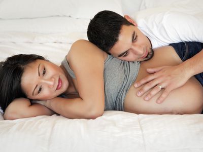 Pregnant woman laying on bed