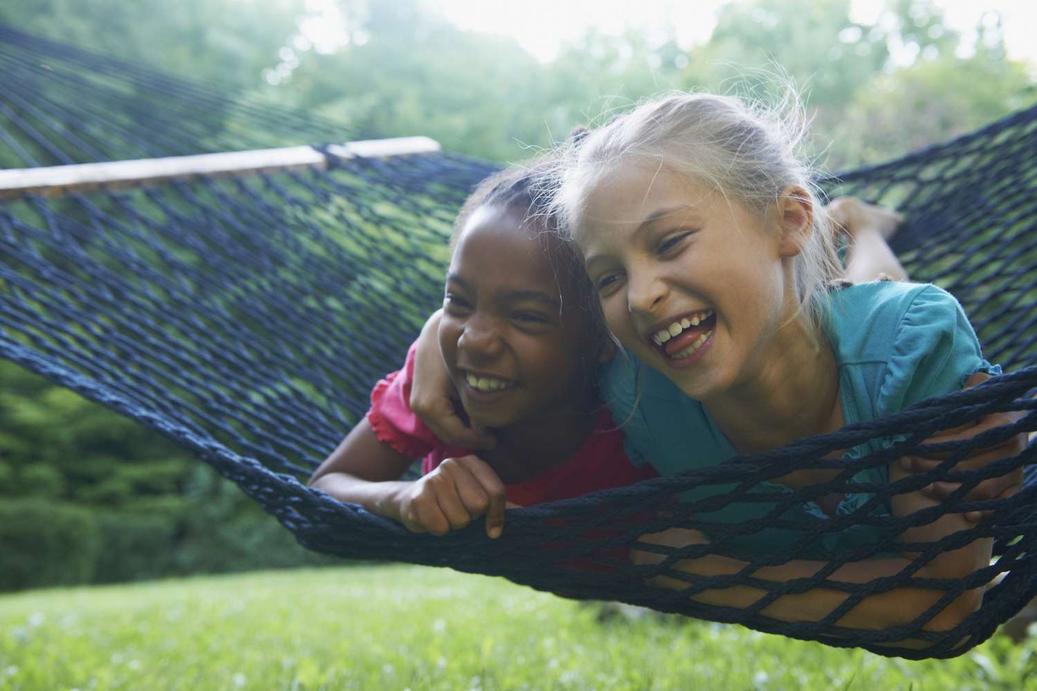 Two best friends laughing on a hammock