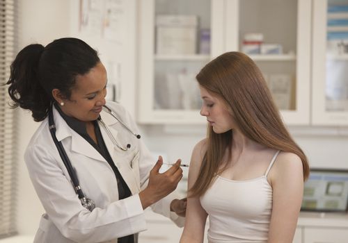 A teenager getting caught up on her vaccines.