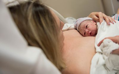 Newborn laying on mom's chest with open eyes