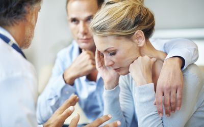 Doctor explaining medical details about miscarriage to a couple