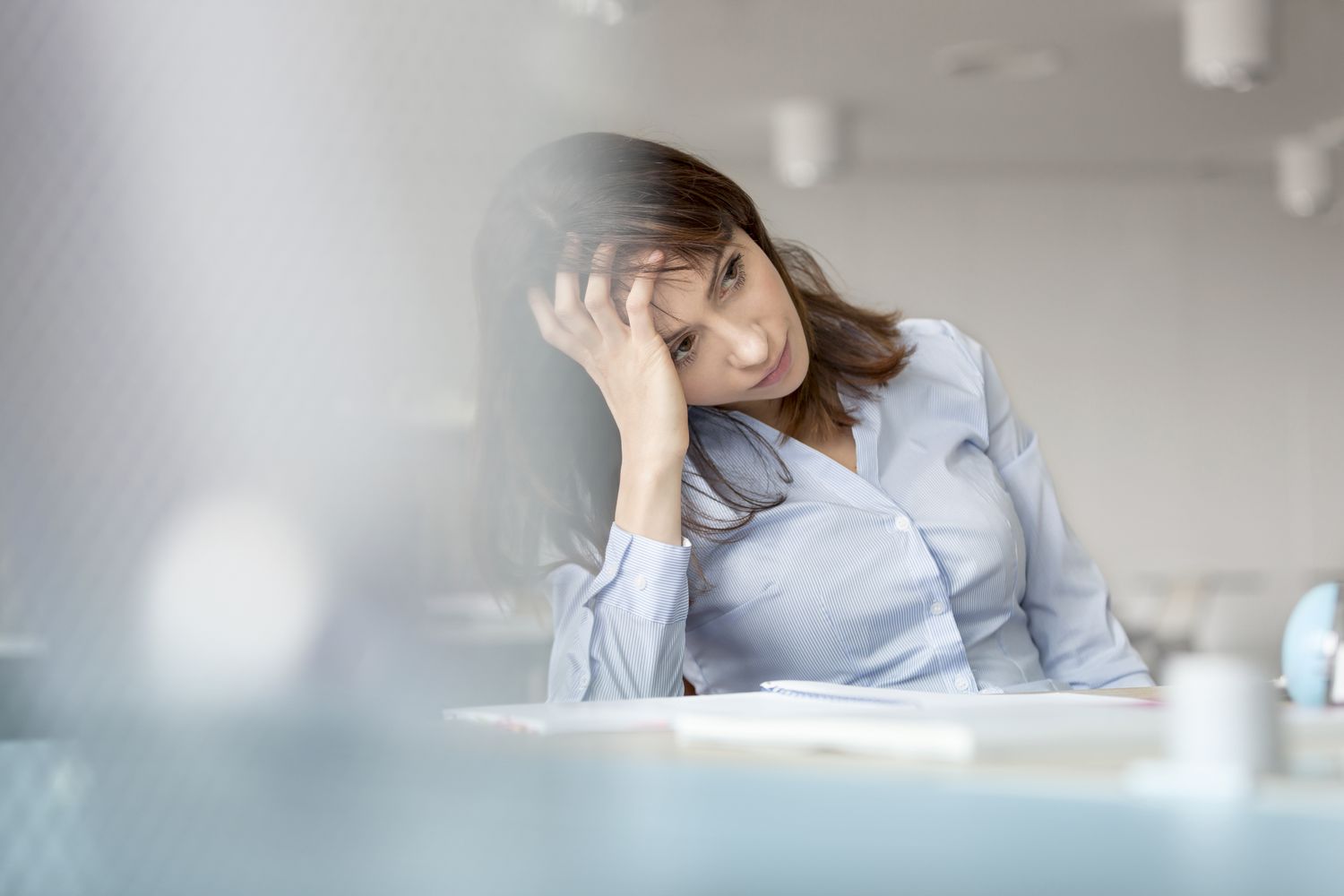 Tired businesswoman with head in hands looking away