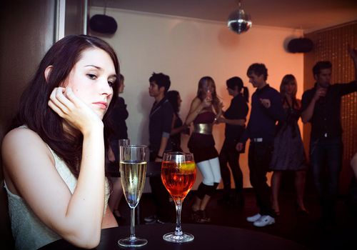 young woman is sitting alone in a nightclub