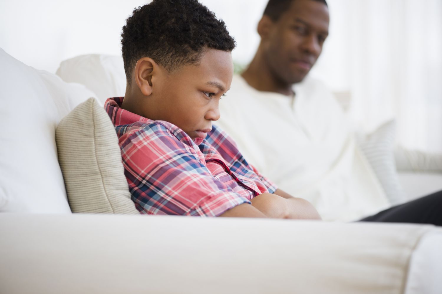 Upset son sitting next to his dad