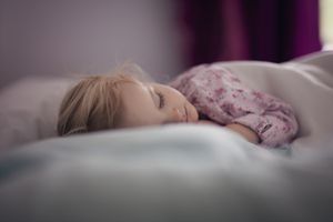 Toddler girl (2-3) sleeping on bed