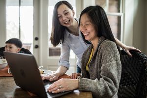 Mother and daughter smiling at the computer