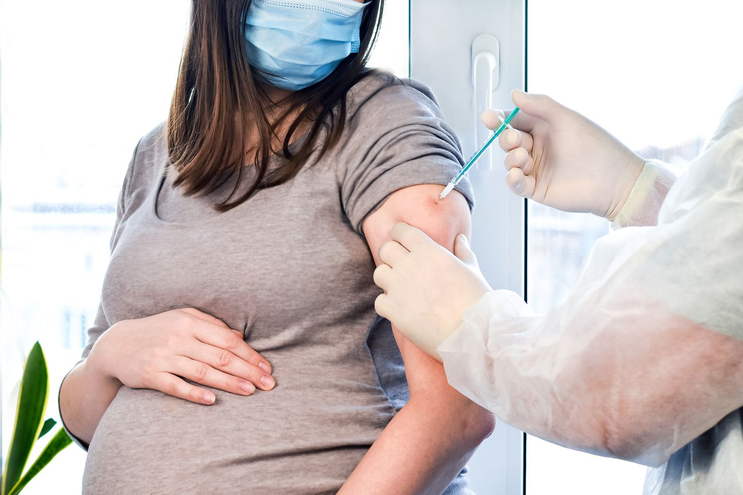 Pregnant woman in doctor's office getting vaccinated