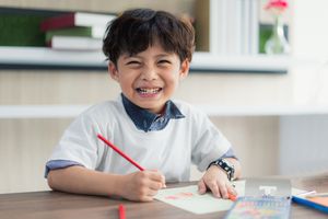 小男孩用彩色铅笔画画